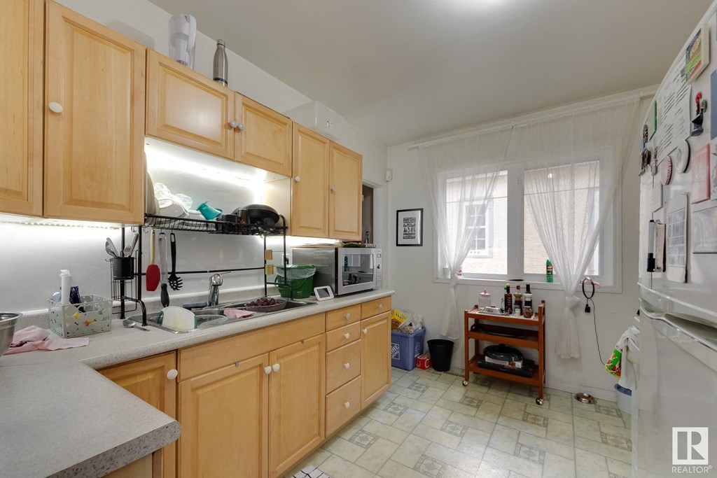 a kitchen with wooden cabinets and a sink and a refrigerator