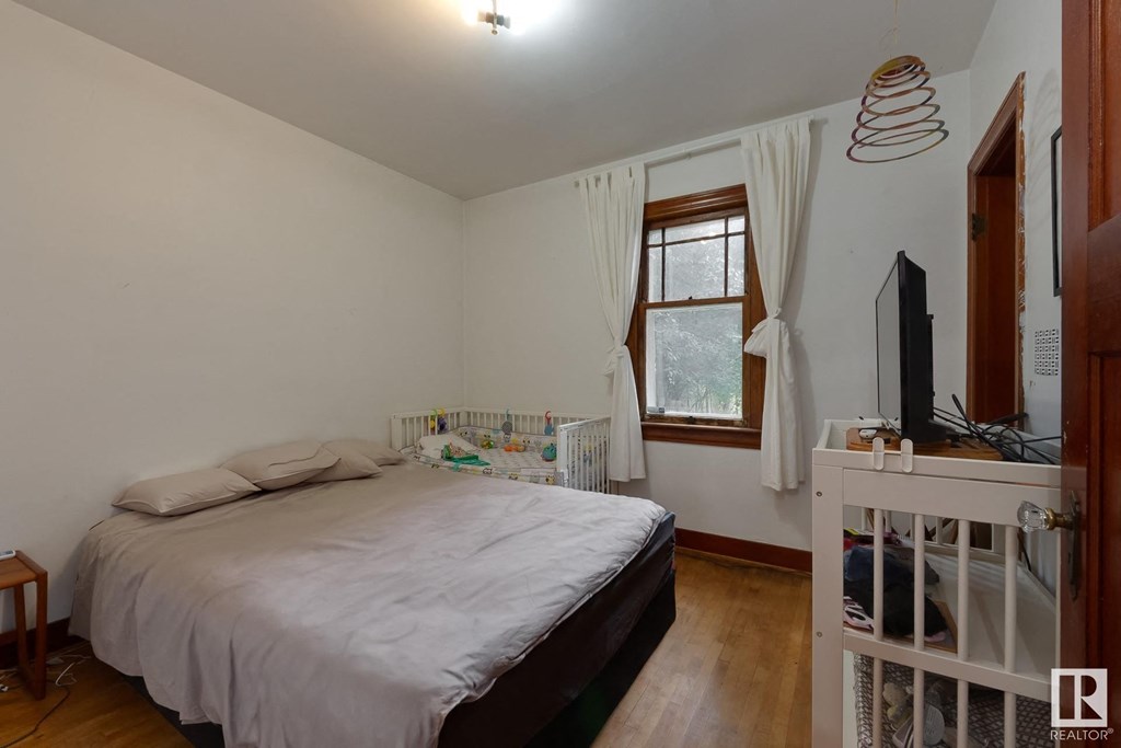 a bedroom with a bed and a crib and a window