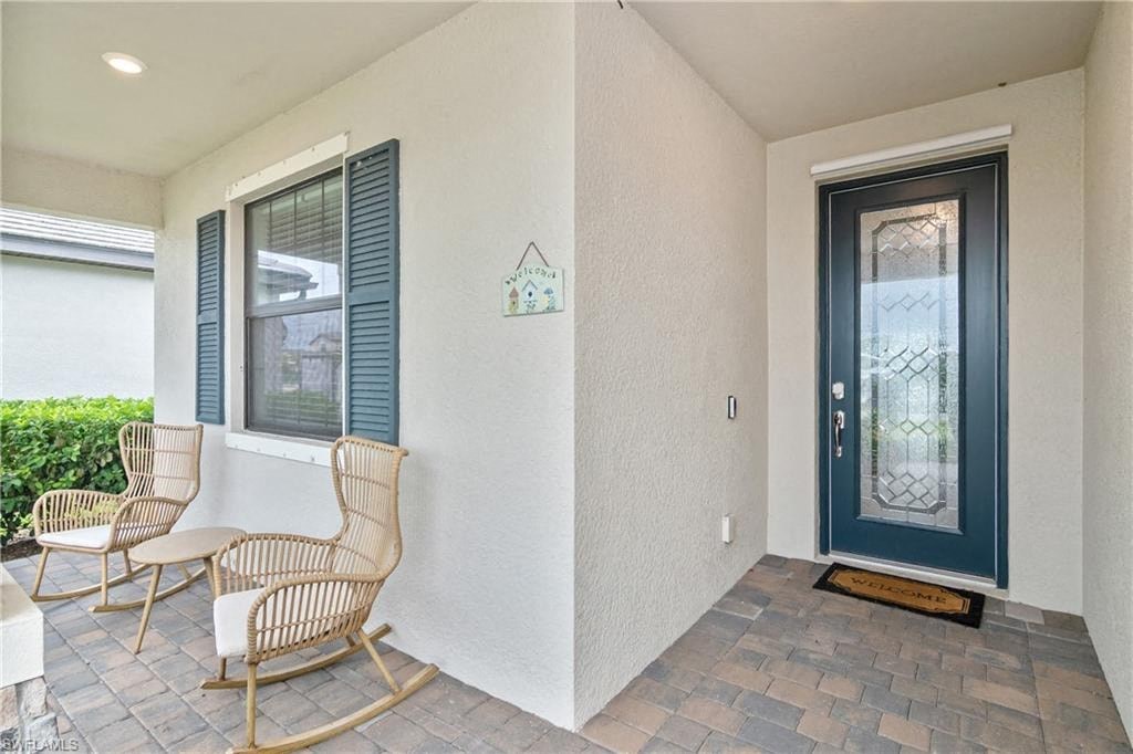the front porch of a house with two rocking chairs and a blue door