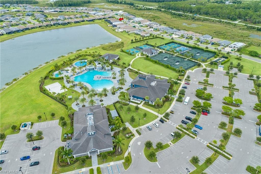 an aerial view of a resort with an outdoor pool and parking lot