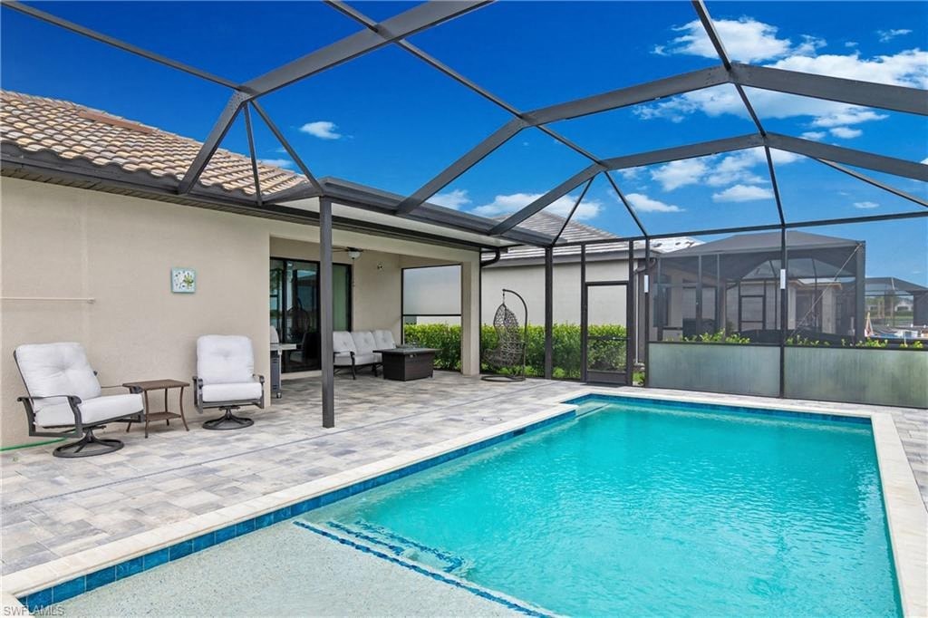 a swimming pool in a house with a patio and chairs