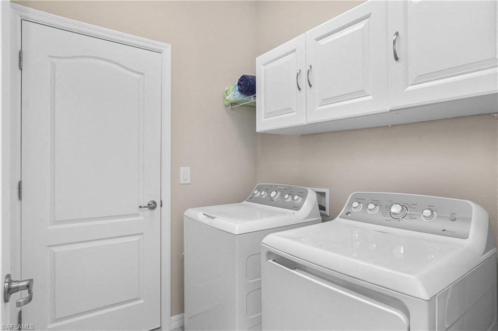 a white laundry room with white appliances and white cabinets
