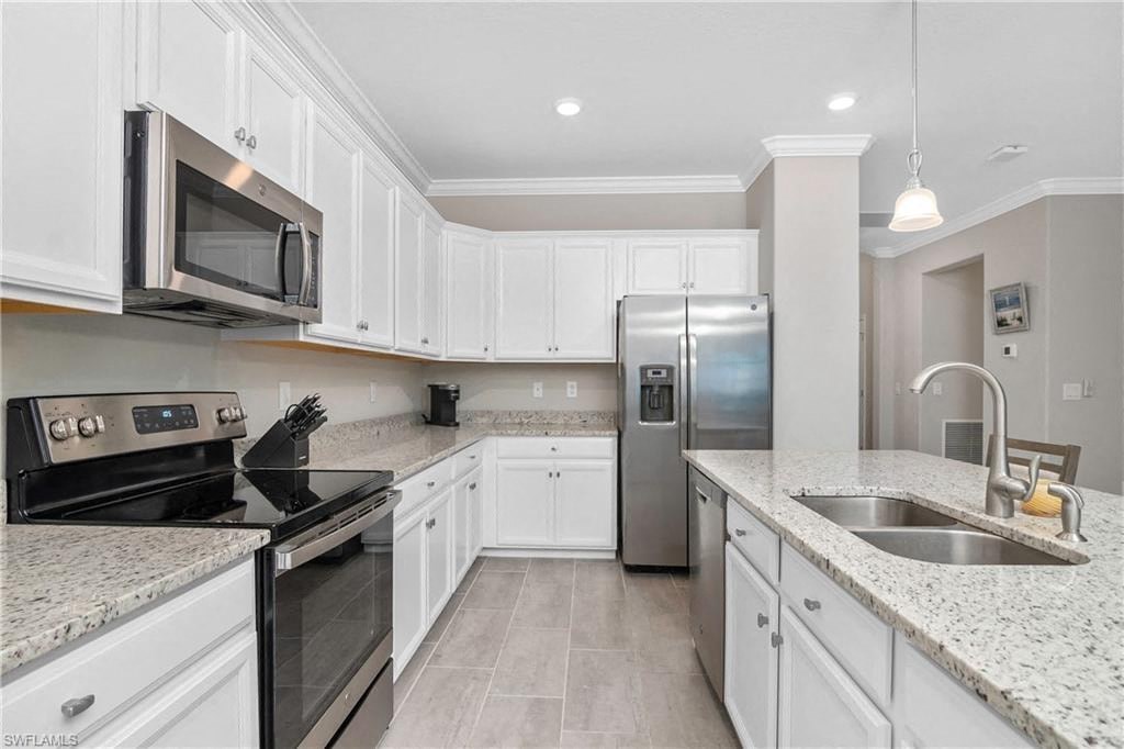 a kitchen with white cabinets and stainless steel appliances