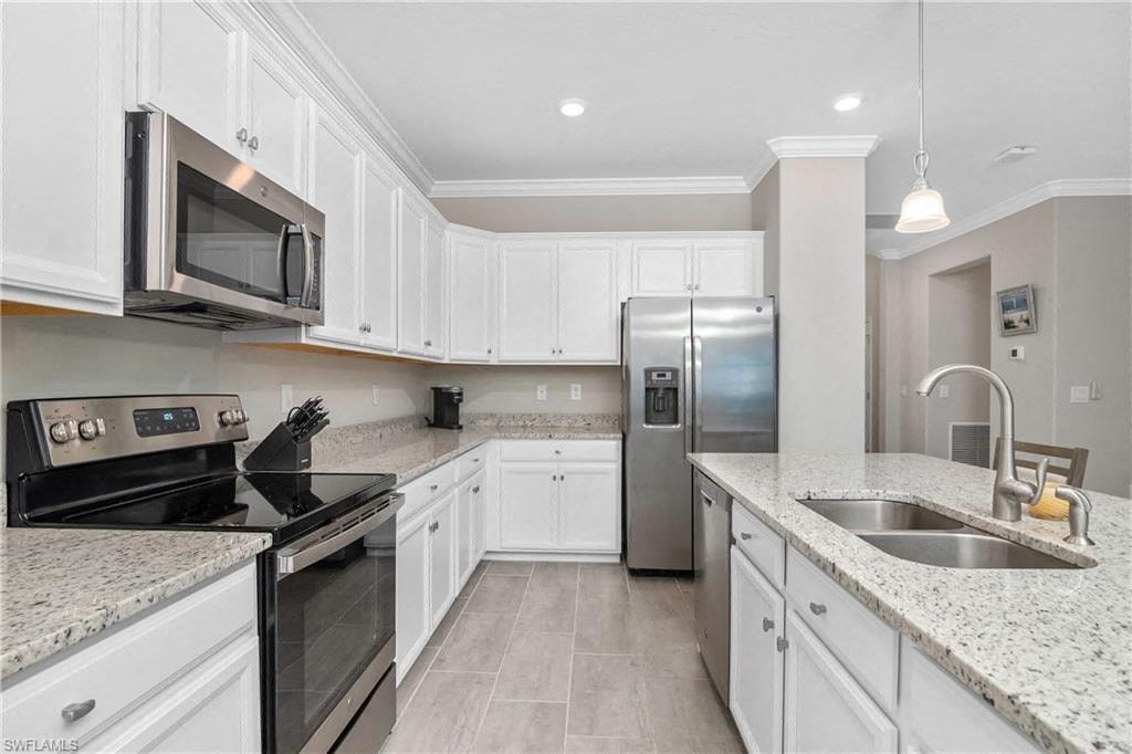 a kitchen with white cabinets and stainless steel appliances