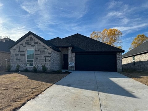 a brick house with a black garage door