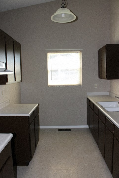 an empty kitchen with a sink and a window