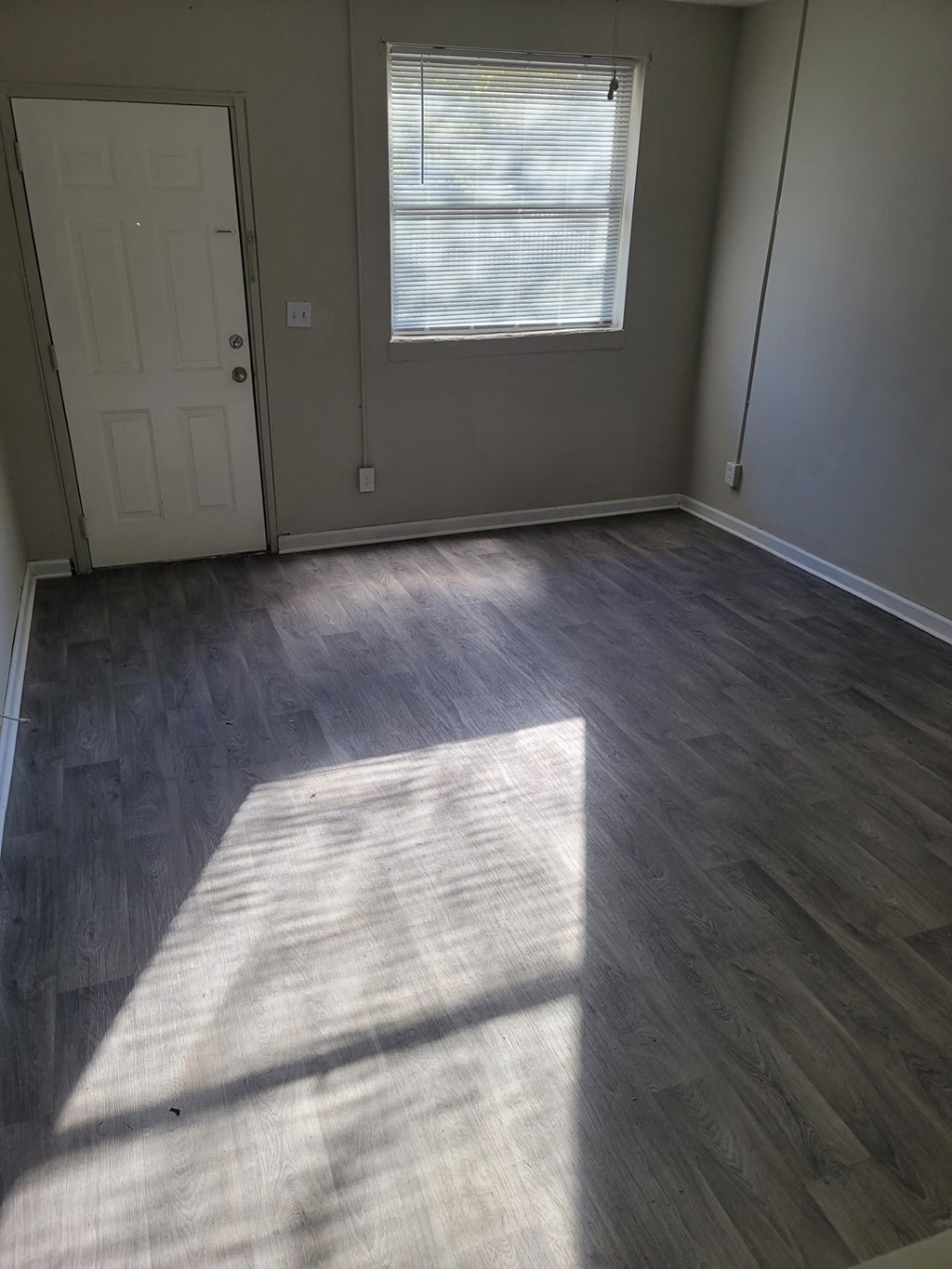 an empty room with a window and a door