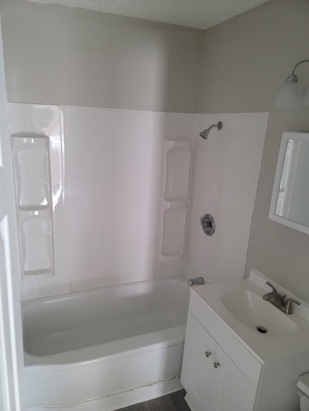 a white bathroom with a sink and a bath tub
