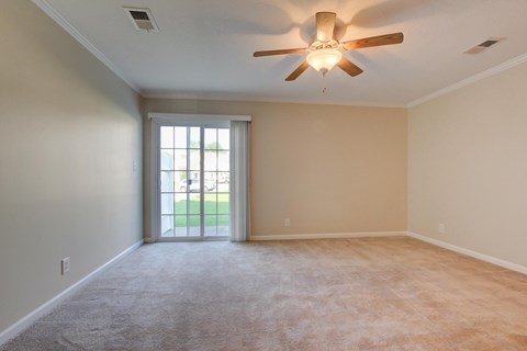 A room with a ceiling fan and carpeted floor.