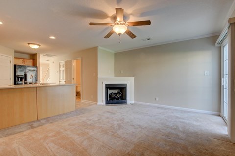 A living room with a fireplace and a ceiling fan.