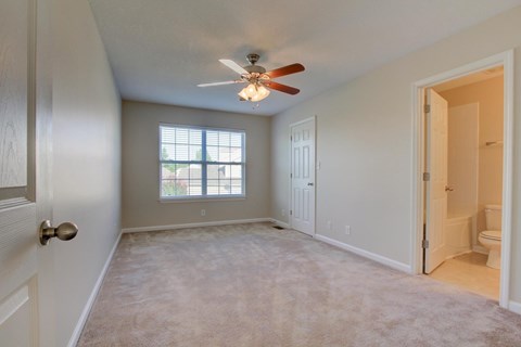 A room with a ceiling fan and a window.