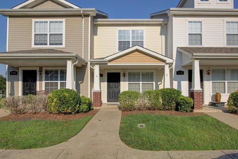 A row of houses with a walkway in the middle.
