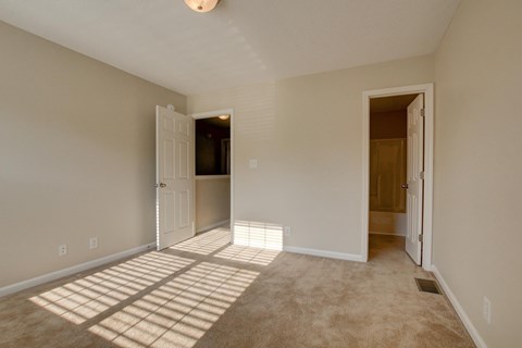 A room with a carpeted floor and a white door.