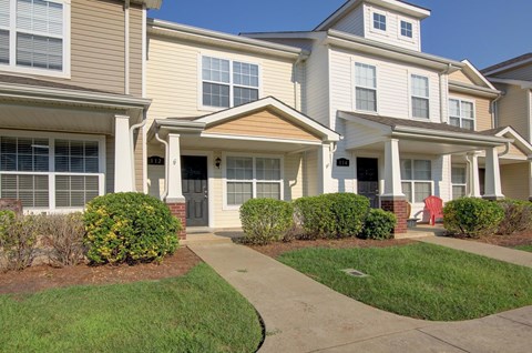 A row of houses with a red sign in the front yard.