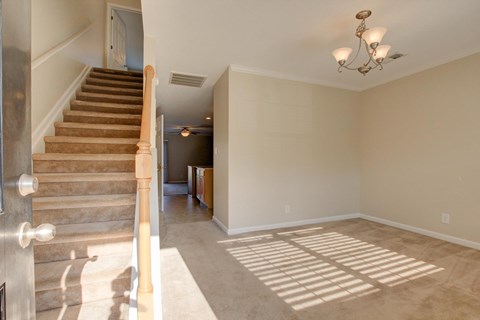 A room with a staircase and a chandelier.