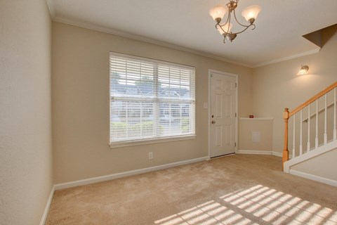 A room with a window, a door, and a chandelier.