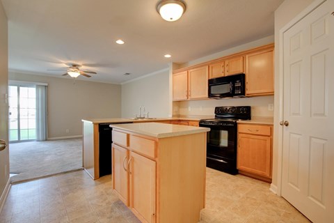 A kitchen with wooden cabinets and black appliances.