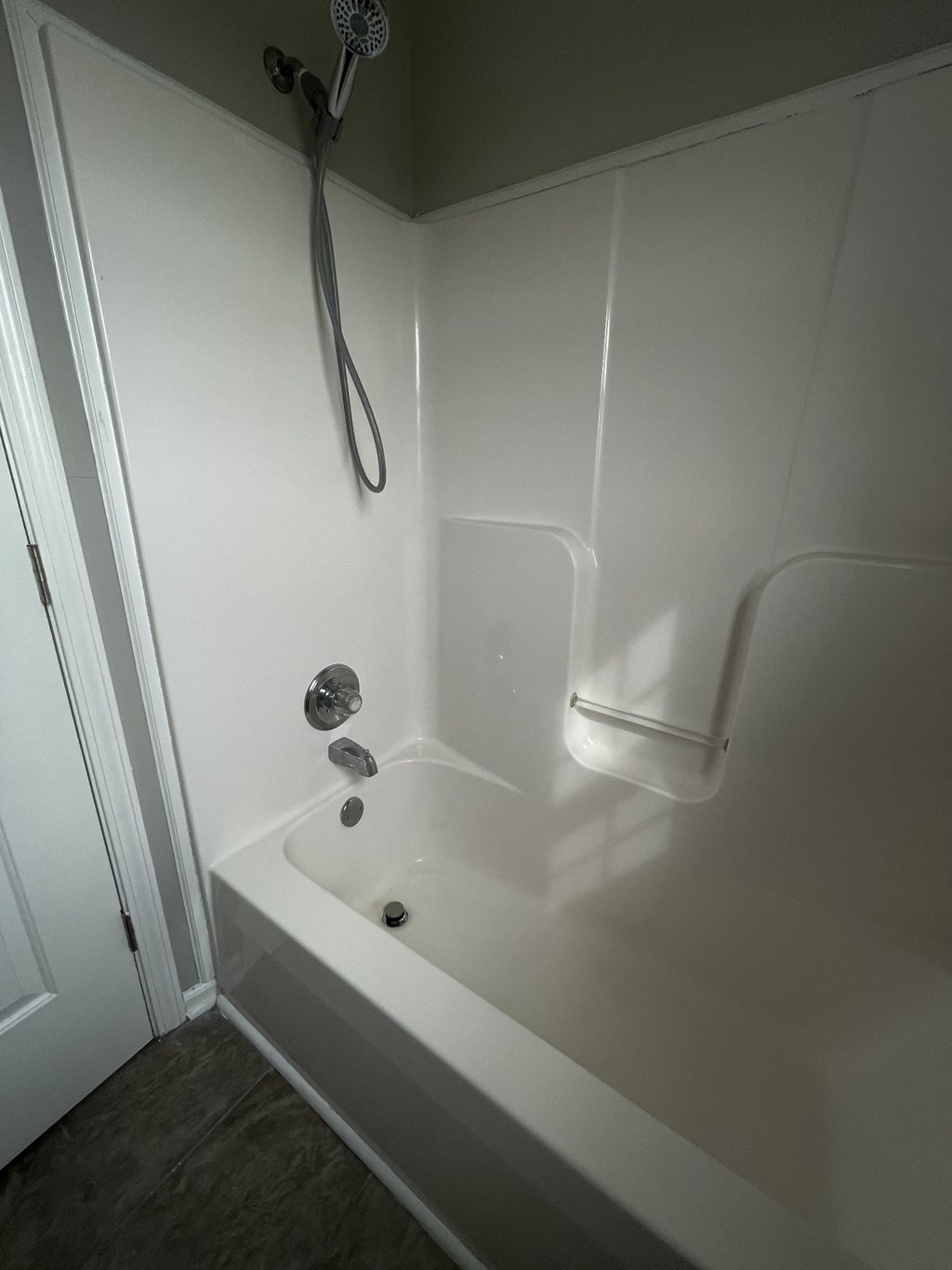 A white bathtub with a shower head and faucet.