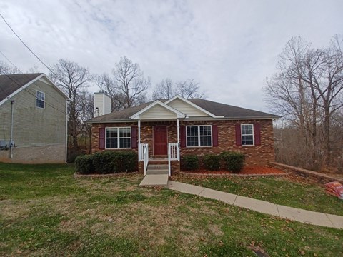 A house with a red door and a white fence.