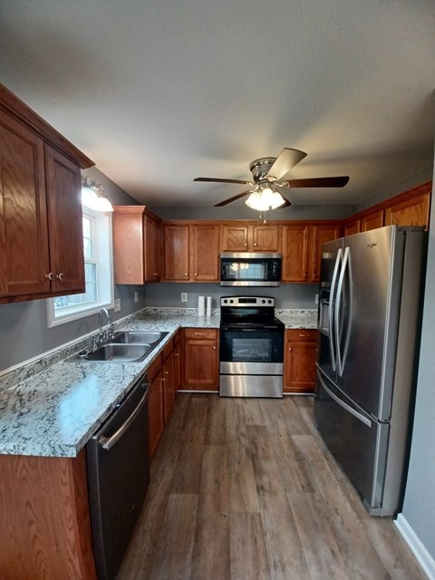 A kitchen with wooden cabinets and a stainless steel refrigerator.