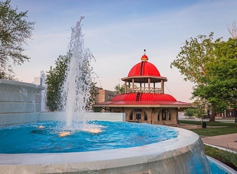 a fountain in front of a building with a red dome