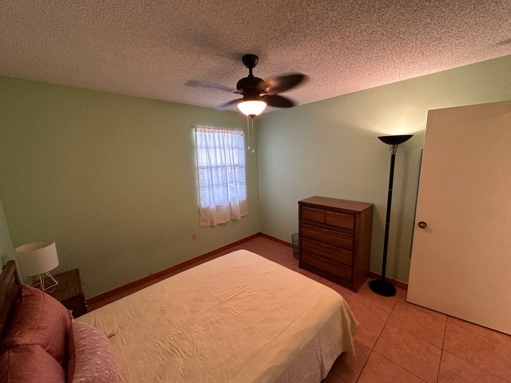 a bedroom with a bed and a ceiling fan
