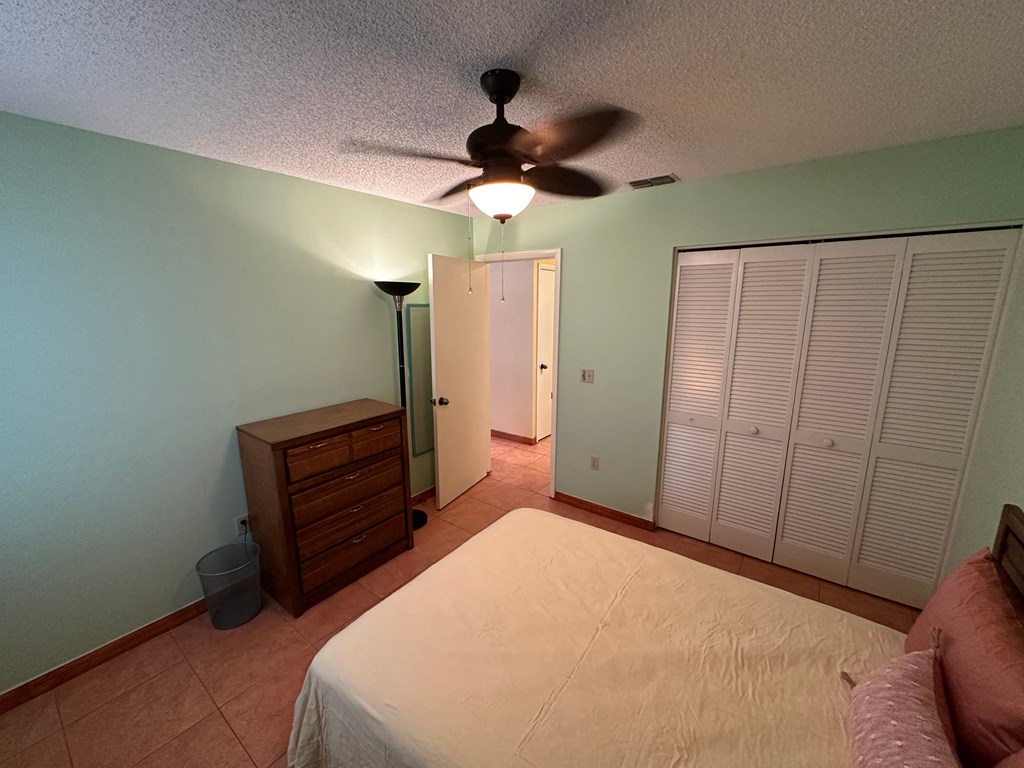 a bedroom with a large bed and a ceiling fan