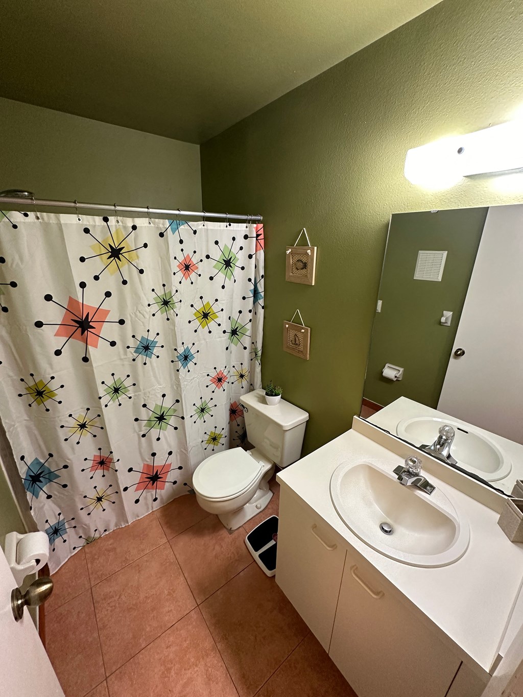 a bathroom with a sink and a toilet and a shower curtain
