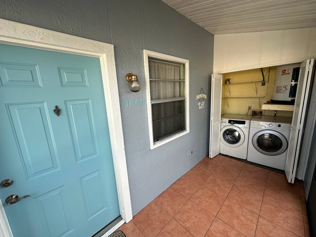 a laundry room with a blue door and two washing machines