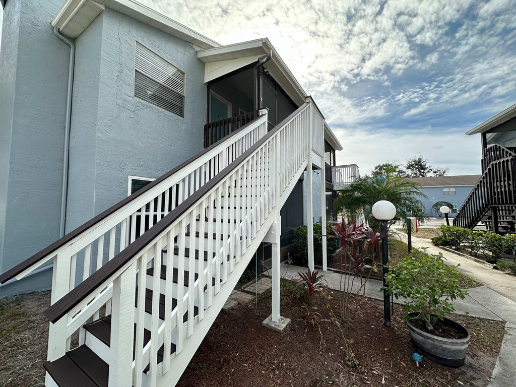 a white staircase leading up to a blue house