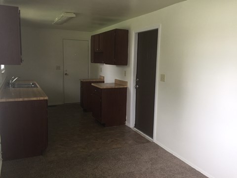 A kitchen with brown cabinets and a counter.