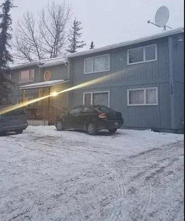 a car parked in front of a house in the snow