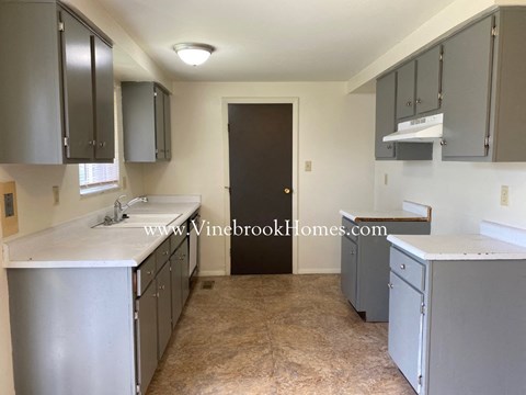 a small kitchen with stainless steel appliances and white counter tops