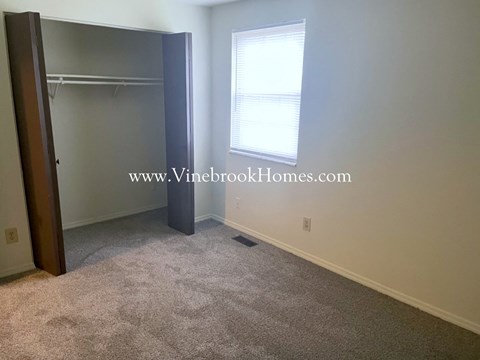 A bedroom with a large mirror and a window.