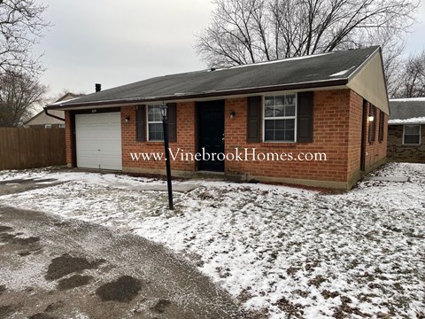 a small brick house with snow on the ground