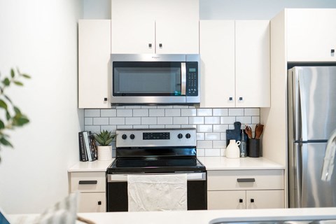 a kitchen with white cabinets and a black stove