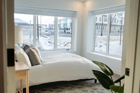 a bedroom with a bed and three windows