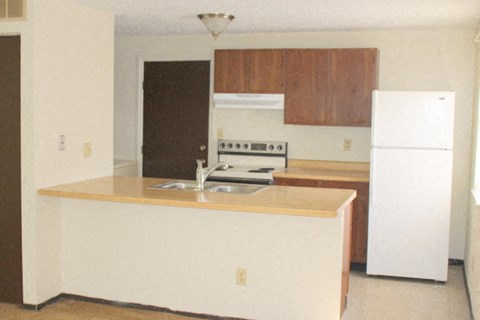 A kitchen with white appliances and wooden cabinets.