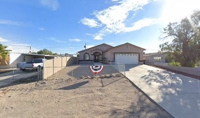 a house with a yard and a fence in front of it