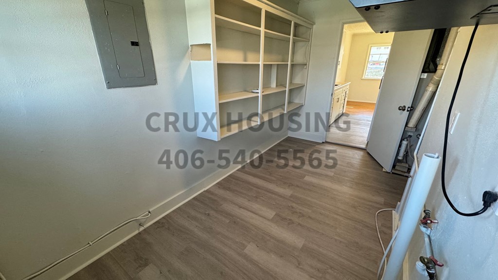 a walk in closet in a living room with a book shelf