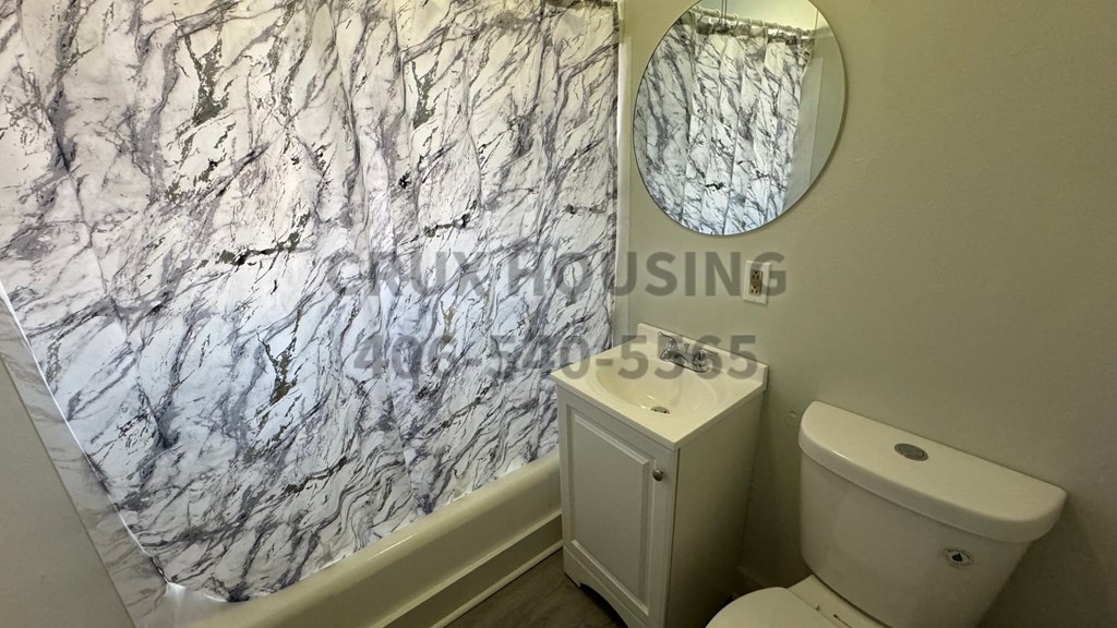 a bathroom with a marble wall and a white toilet