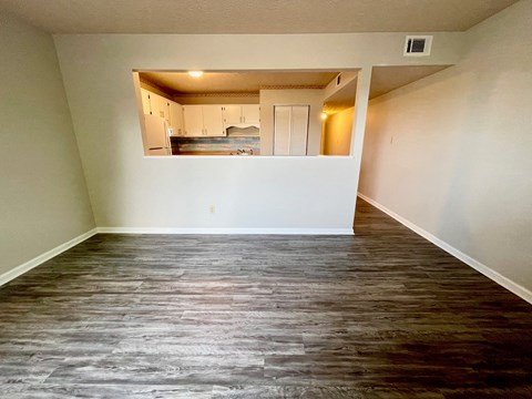 an empty living room with white walls and a wooden floor