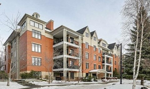 a large brick apartment building with snow on the ground