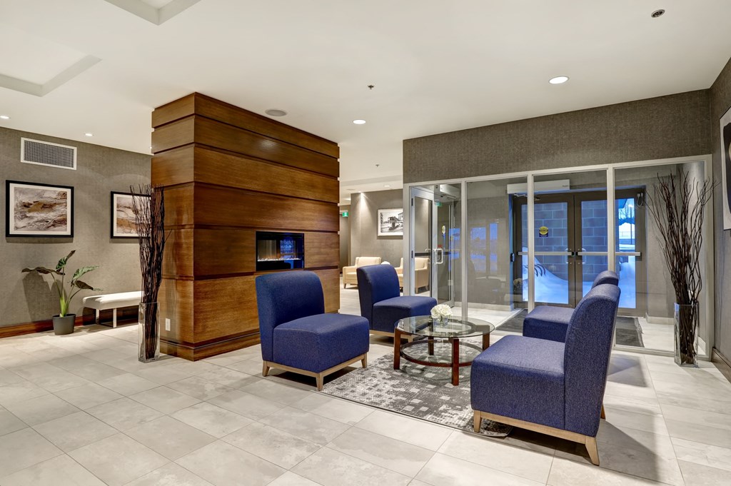 a lobby with blue chairs and a fire place