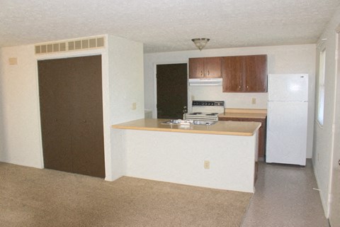 A kitchen with white appliances and brown cabinets.