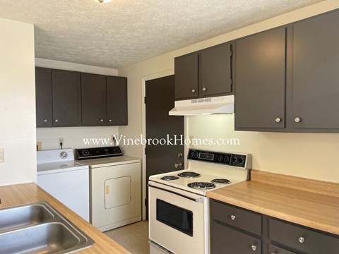 a kitchen with white appliances and black cabinets
