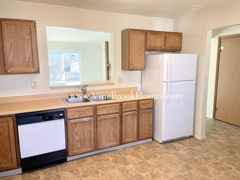 a kitchen with wooden cabinets and a white refrigerator