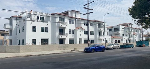 a blue car parked on a street in front of white buildings