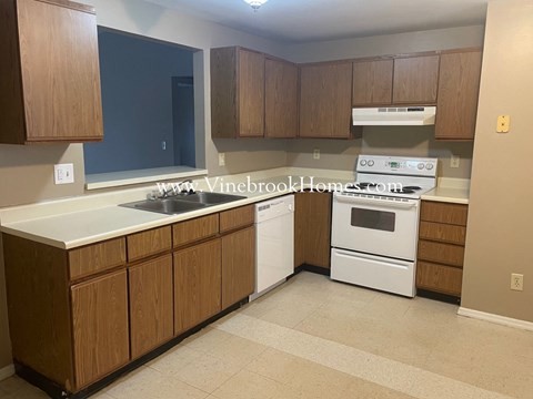 a small kitchen with white appliances and wooden cabinets