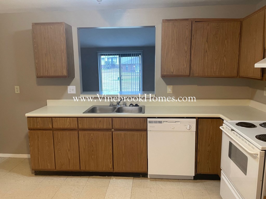 a kitchen with white appliances and wooden cabinets